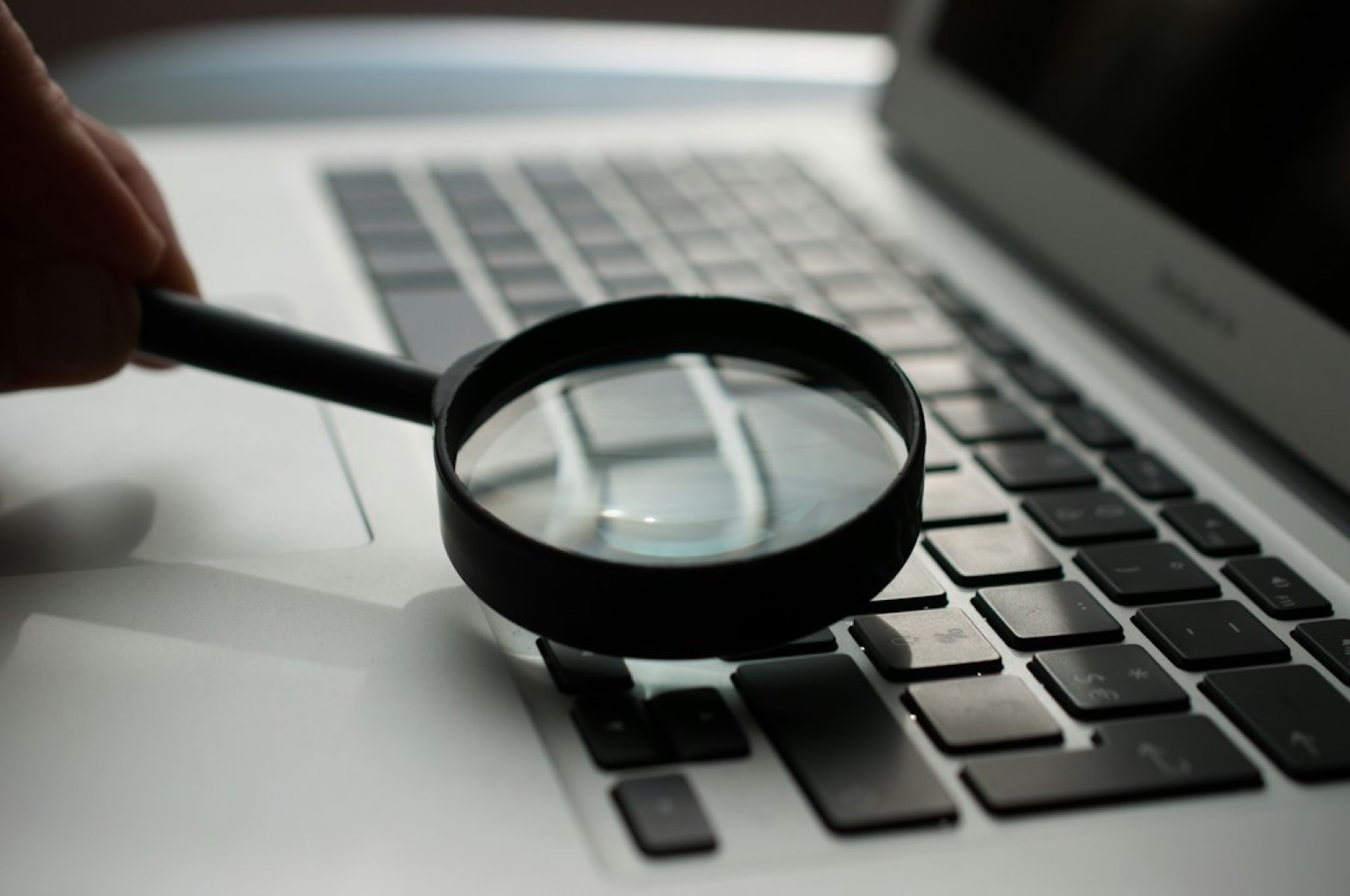 loupe analysant le code source d'une page web pour un audit SEO