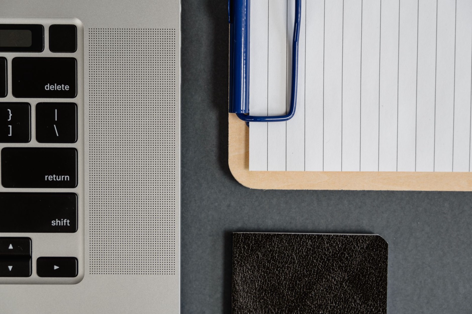 Ordinateur portable et carnet de notes sur un bureau, pour préparer les vérifications avant de choisir une agence web