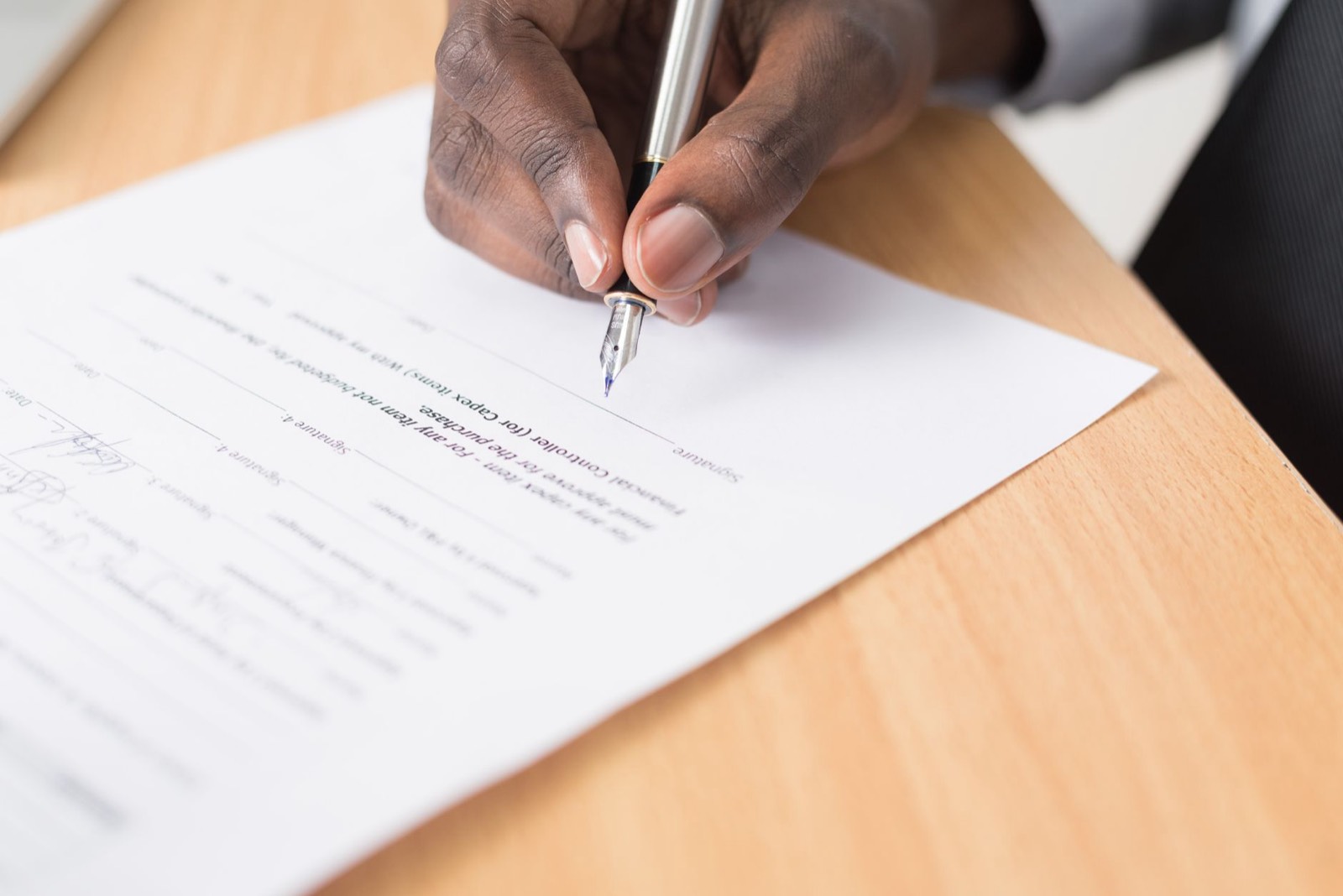Signature d'un contrat de création de site internet avec un stylo sur un document